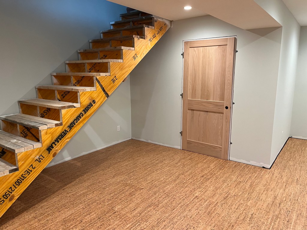 Basement finishing in progress, showing the cork floor and mechanical room door 