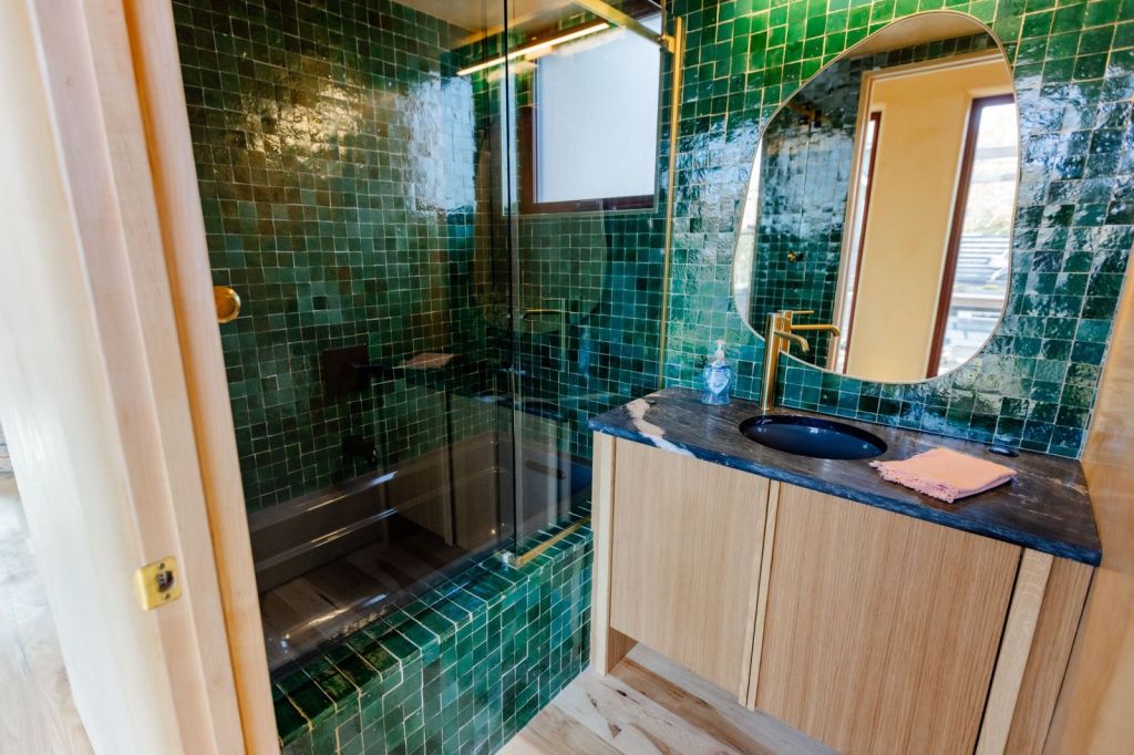 Emerald green tile work next to custom oak bathroom vanity